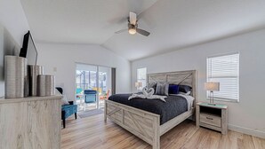 A bedroom with a wooden bed, a ceiling fan, and a view to the outside. - ⭐NEWLY REFURBISHED | 4 Bed Villa | Large Private Pool Deck | Minutes to Disney⭐ (Davenport)