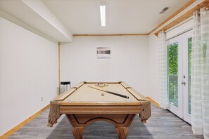 A pool table in a hallway with a door leading to a balcony. - Cosy Cabin|King Suite main floor|Game Room|Hot Tub (Gatlinburg)