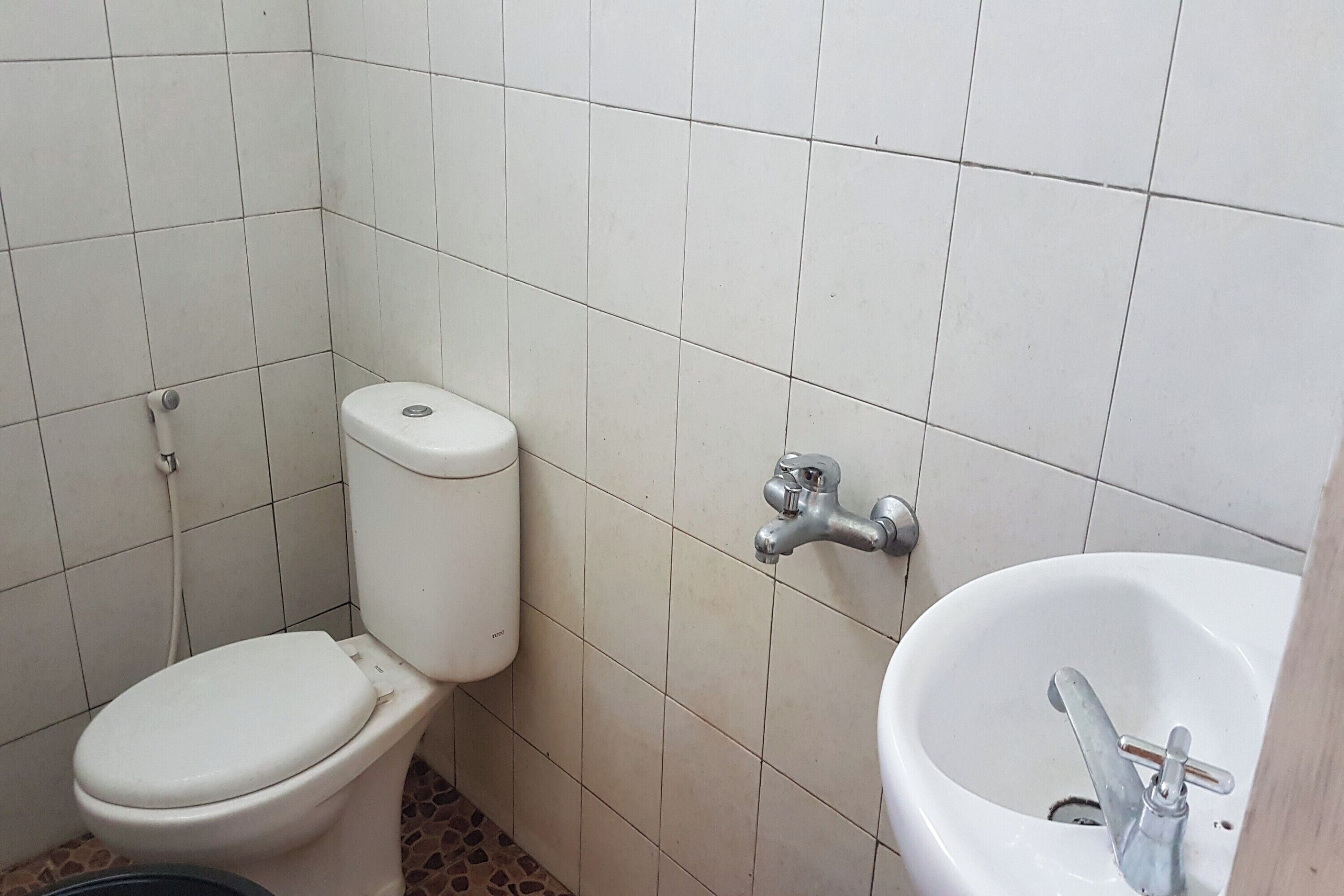 Un baño pequeño con inodoro, lavamanos y paredes de azulejos.