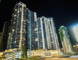 Un edificio de gran altura con varios pisos, amplias ventanas y un diseño arquitectónico moderno.