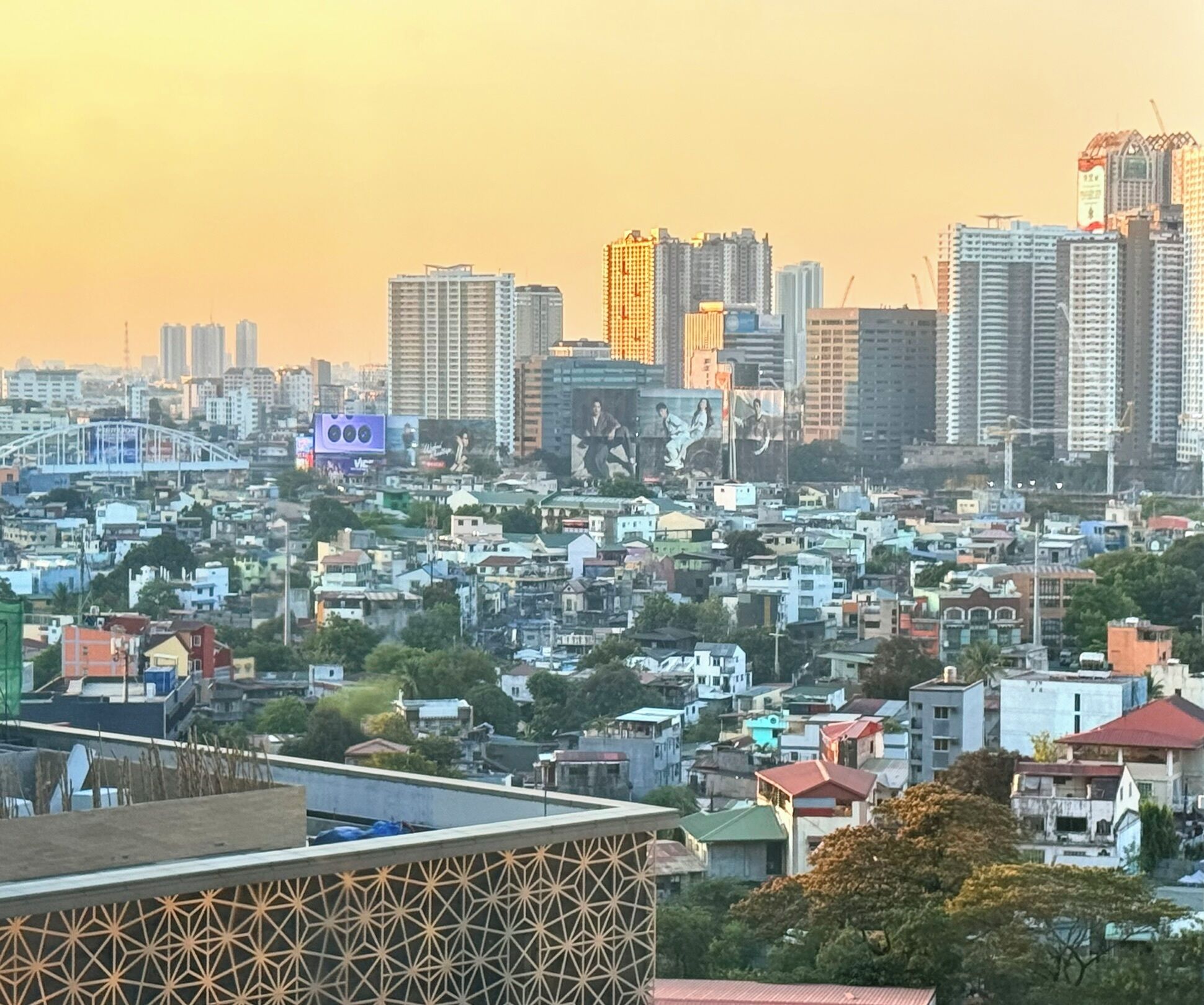 Un paysage urbain avec de hauts immeubles, un pont et un quartier résidentiel densément peuplé.