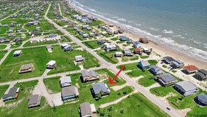 An aerial view of a coastal residential area with houses, roads, and a beach. - Surfside Retreat - Great Views & Steps from Beach (Freeport)