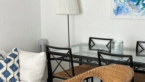 A living room with a sofa, a wicker chair, a glass coffee table, a lamp, and a painting on the wall. - A little corner of Paradise - 4 minutes walk to the beach and restaurants (Saint-Cyr-sur-Mer)