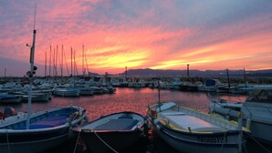 A marina at sunset with boats docked, calm water, and distant mountains. - A little corner of Paradise - 4 minutes walk to the beach and restaurants (Saint-Cyr-sur-Mer)
