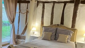 Une chambre à coucher avec un lit, des tables de chevet et une fenêtre avec des rideaux.