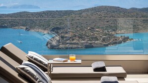 A balcony with a view of a coastal landscape, including a small island and mountains in the background. - Notiko villas (Agios Nikolaos)
