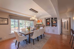 Enjoy meals in the spacious dining area with a large table and six chairs, surrounded by a stylish kitchen with an island.