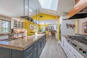 Enjoy cooking in this well-equipped kitchen with a central island, stainless steel sink, and large stove.