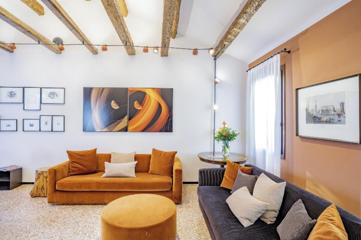 A modern living room with a sofa and ottoman, a coffee table, and artwork on the walls.