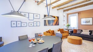 A modern living room with a dining table set for a meal, a sofa, and a coffee table.