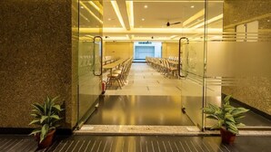 A conference room with glass walls, a long table, and chairs. - Patel Comforts Inn & Suites (Mysore)