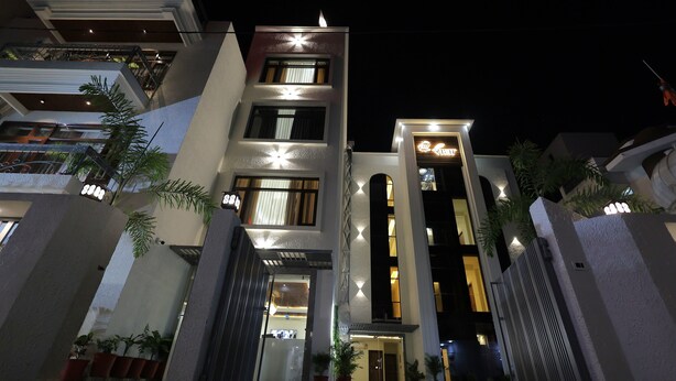 A modern multi-story building with a well-lit entrance, large windows, and a gated driveway. - Shree radha heritage (Haridwar)