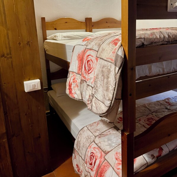 Una cama litera con una colcha de estampado floral y un cabecero de madera.