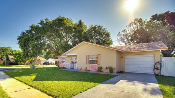 A single-story house with a garage, a well-maintained lawn, and a clear sky. - 7 Mi to Satellite Beach: Melbourne Home w/ Yard (Melbourne)