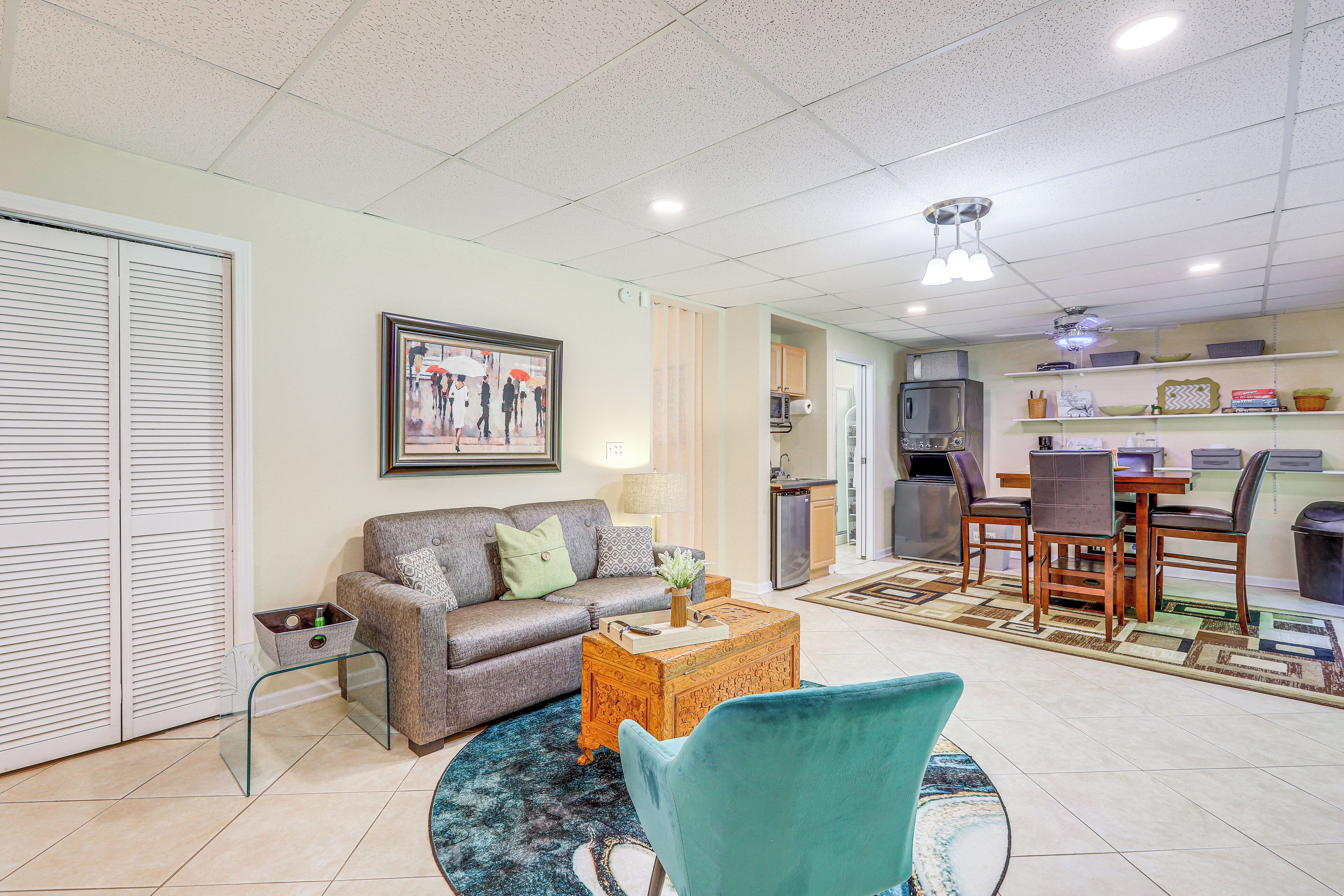 A living room with a sofa, a coffee table, and a dining area with chairs and a table.