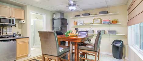 A compact kitchen with a dining area, microwave, and a small television.