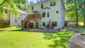 A two-story house with a covered patio, a wooden deck, and a red umbrella. - Cozy Jonesboro Studio w/ Patio ~ 22 Mi to Atlanta! (Jonesboro)