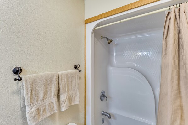 A bathroom with a bathtub, a toilet, and a towel rack with two towels. - Lead Home in the Mountains w/ Hot Tub + Views! (Lead)