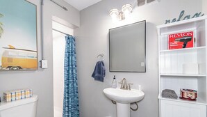 A bathroom with a toilet, sink, and shower curtain.