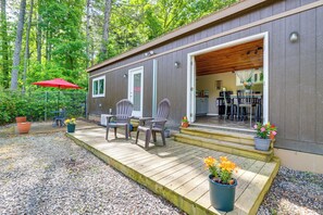 A cabin with a wooden deck, outdoor seating, and potted plants. - Cozy + Convenient Blairsville Cabin w/ Deck! (Blairsville)