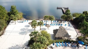 A beachside resort with a sandy area, palm trees, and a dock extending into a calm lake. - 3 Bed 2 Bath Condo Bahama Bay Resort 3 Bedroom Condo by RedAwning (Davenport)