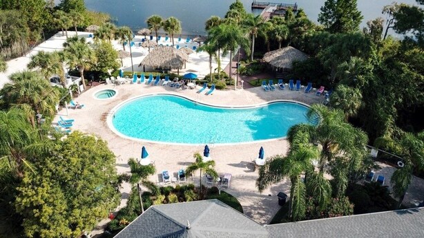 A resort with a large swimming pool, lounge chairs, and a dock extending into a lake. - 3 Bed 2 Bath Condo Bahama Bay Resort 3 Bedroom Condo by RedAwning (Davenport)