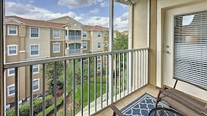 A balcony with a view of a residential building, a door with a window, and a patterned rug. - Summer Dreams 3 Bed Condo In Windsor Hills 3 Bedroom Condo by RedAwning (Kissimmee)