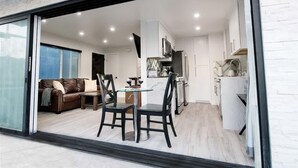 A modern apartment with a dining area, kitchen, and living room.