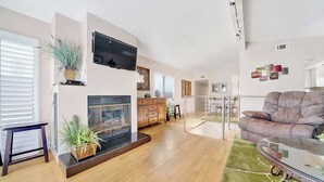 Una sala de estar moderna con chimenea, televisor de pantalla plana y zona de estar acogedora.