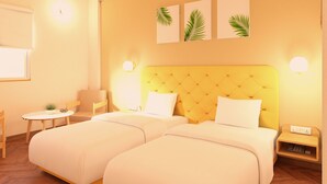 Habitación de hotel con dos camas, una mesita, una silla y una mesita de noche con teléfono.