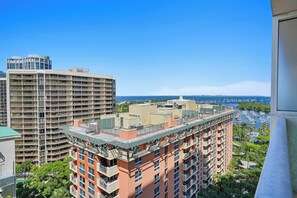 Un immeuble de grande hauteur doté de nombreux balcons et offrant une vue sur un port de plaisance.