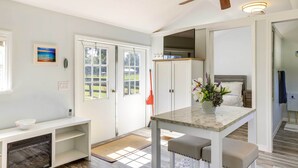 Una cucina moderna con mobili bianchi, un piano di lavoro in marmo e una ventola a soffitto.