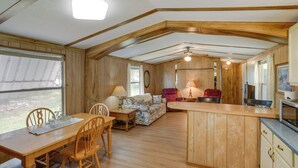 A wooden interior with a dining table, chairs, a sofa, and a kitchen area. - Blackwell Home w/ Enclosed Porch: Steps to Water! (Blackwell)