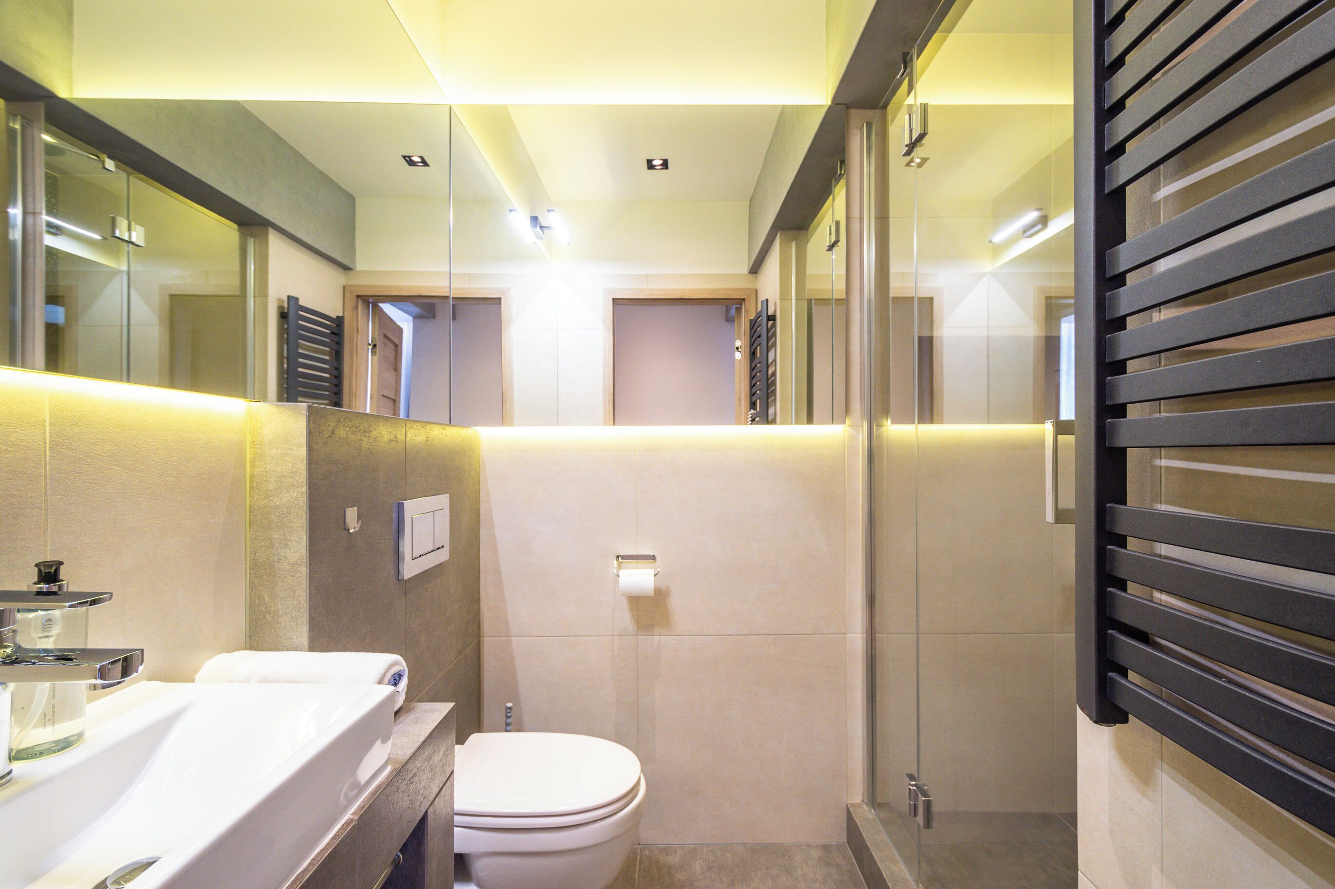 A modern bathroom with a toilet, sink, and shower area.
