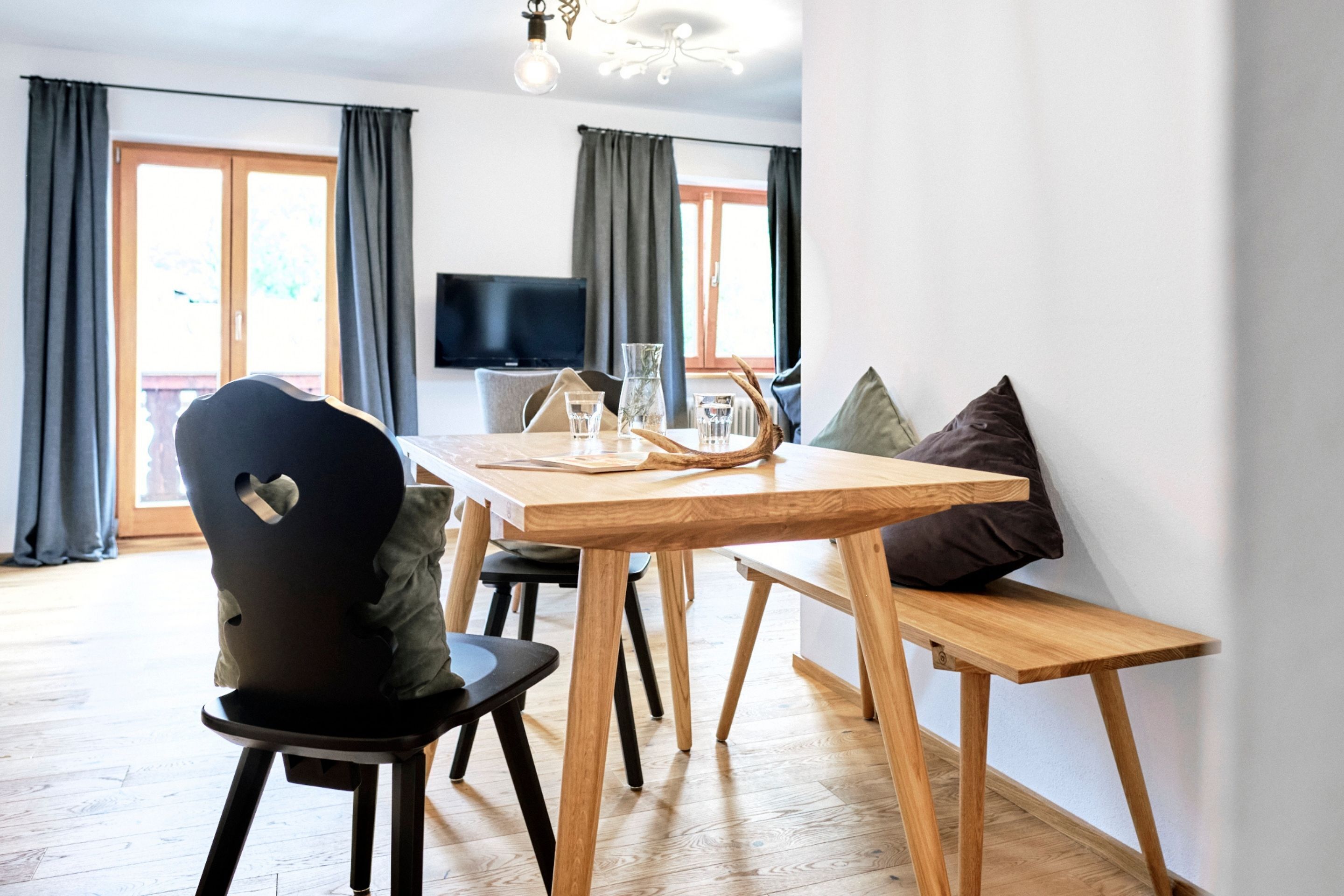 Un espace repas moderne avec une table en bois, des chaises et un banc.