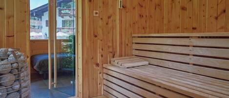 A wooden interior with a bench and a stone wall.