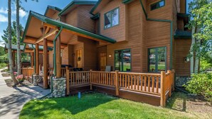 A two-story log cabin with a covered porch and a stone foundation. - Relax and Recharge at The Retreat at The Enclave – Mountain Views, Hot Tub, and (Steamboat Springs)