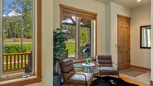 A spacious room with large windows, a wooden door, and a view of a green landscape. - Relax and Recharge at The Retreat at The Enclave – Mountain Views, Hot Tub, and (Steamboat Springs)