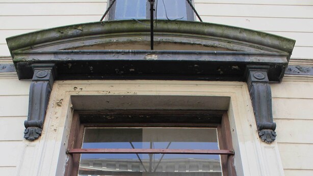 Un bâtiment sur lequel on peut lire l’inscription « HÔTEL POUR TOURISTES » et où le chiffre « 5 » est apposé sur la porte.