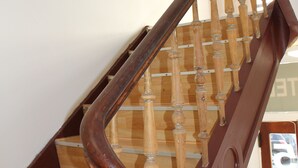 Un escalier en bois doté d’une main courante incurvée et de balustres en bois.