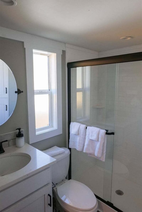 Une salle de bain moderne équipée de toilettes, d’un lavabo et d’une douche.