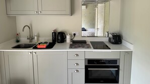 Una cocina compacta con un lavabo, estufa y tostadora.