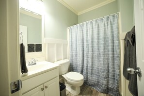 A bathroom with a white sink, a toilet, and a shower curtain.