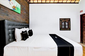 Relax in a stylish room with a large bed, tufted headboard, and a window with a decorative frame.