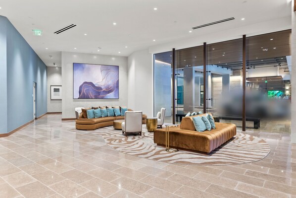 A modern lobby with a sectional sofa, a round coffee table, and a zebra-patterned rug.
