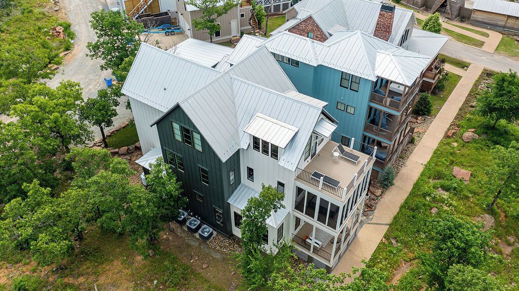 En høj boligbygning med moderne arkitektur, der har en kombination af mørkeblå og lyseblå facader, flere altaner og et rummeligt udendørs dækareal.