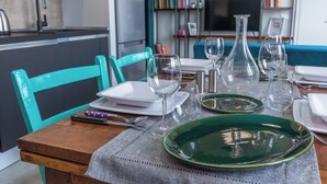 A dining table set with plates, glasses, and cutlery in a modern kitchen and living area. - Casa Ester in San Salvario by Wonderful Italy (Turin)