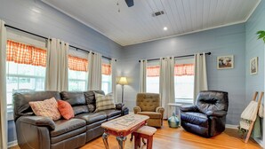 A living room with a brown leather sofa, a wooden coffee table, a brown armchair, and a black leather armchair. - The Farm Haus (Meridian)