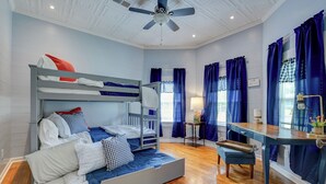 A room with bunk beds, a desk, a chair, and a ceiling fan. - The Farm Haus (Meridian)