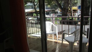 En balkon med udsigt over en gade, et træ og en bygning med et skilt, der siger "Hotel Azzurri".